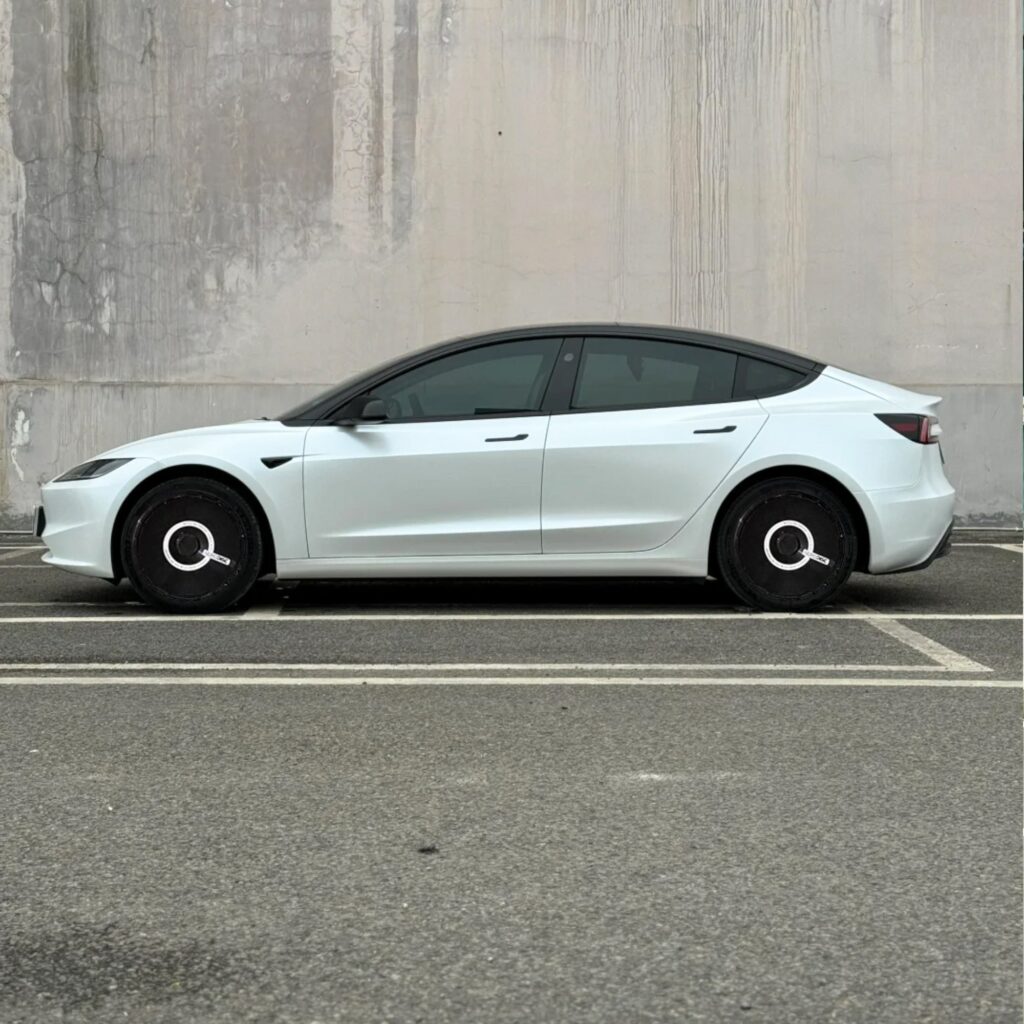 White Tesla Model 3 with custom black wheel covers installed