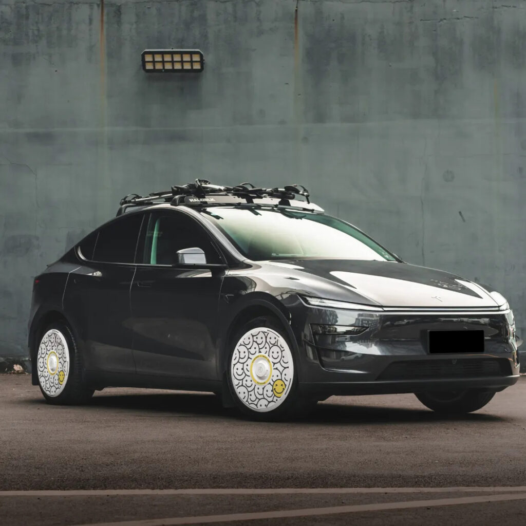 Black Tesla Model Y wearing white smiley-face wheel covers from Nauticrim