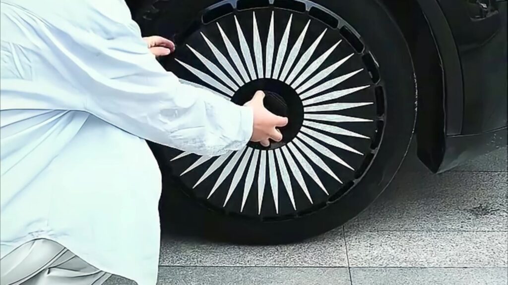 Owner pressing a custom Tesla wheel cover securely onto a Model Y wheel