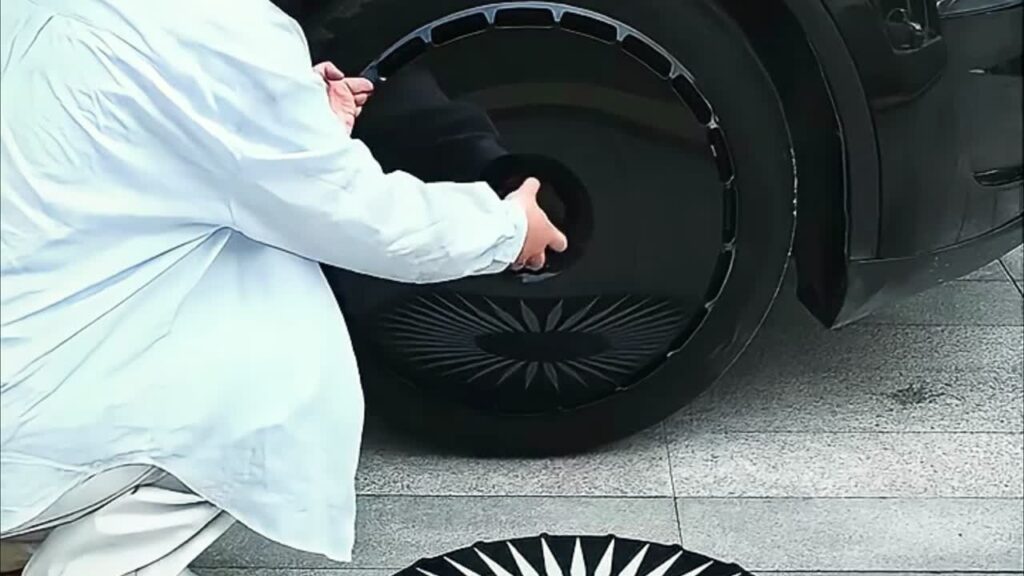 Owner removing a Tesla wheel cover to store it safely off the car