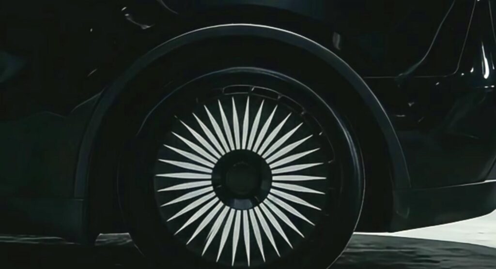 Tesla wheel cover decals on a black and white turbine-style wheel cover close-up