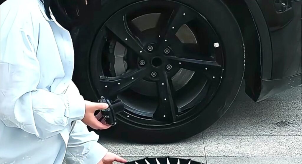 Tesla wheel covers and wheel balance - bare black alloy wheel with removed cover and clip